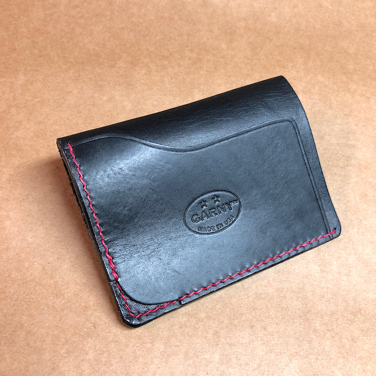 Black minimalist wallet, everyday carry, black leather wallet with red stitching.