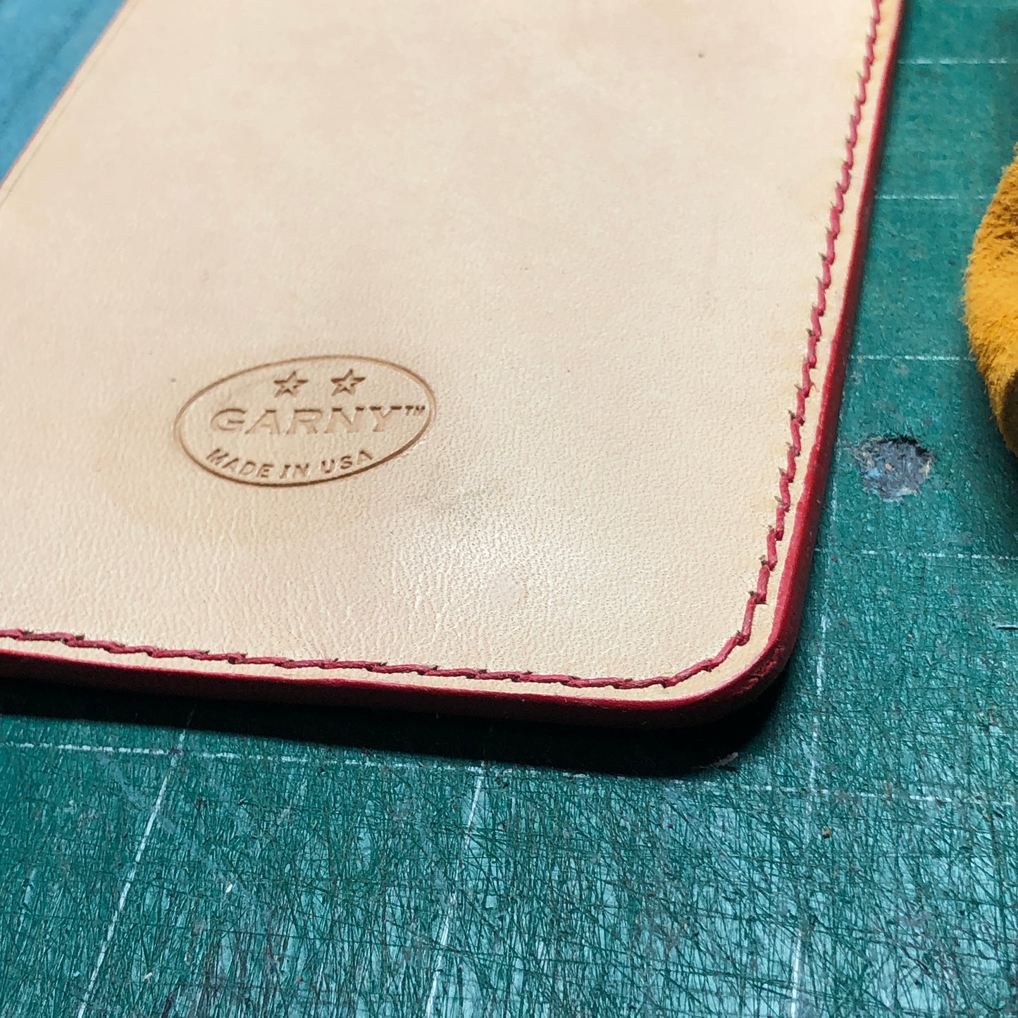 Hand stitching and finished edge of a Leather Field Notes cover with 2 pockets. 