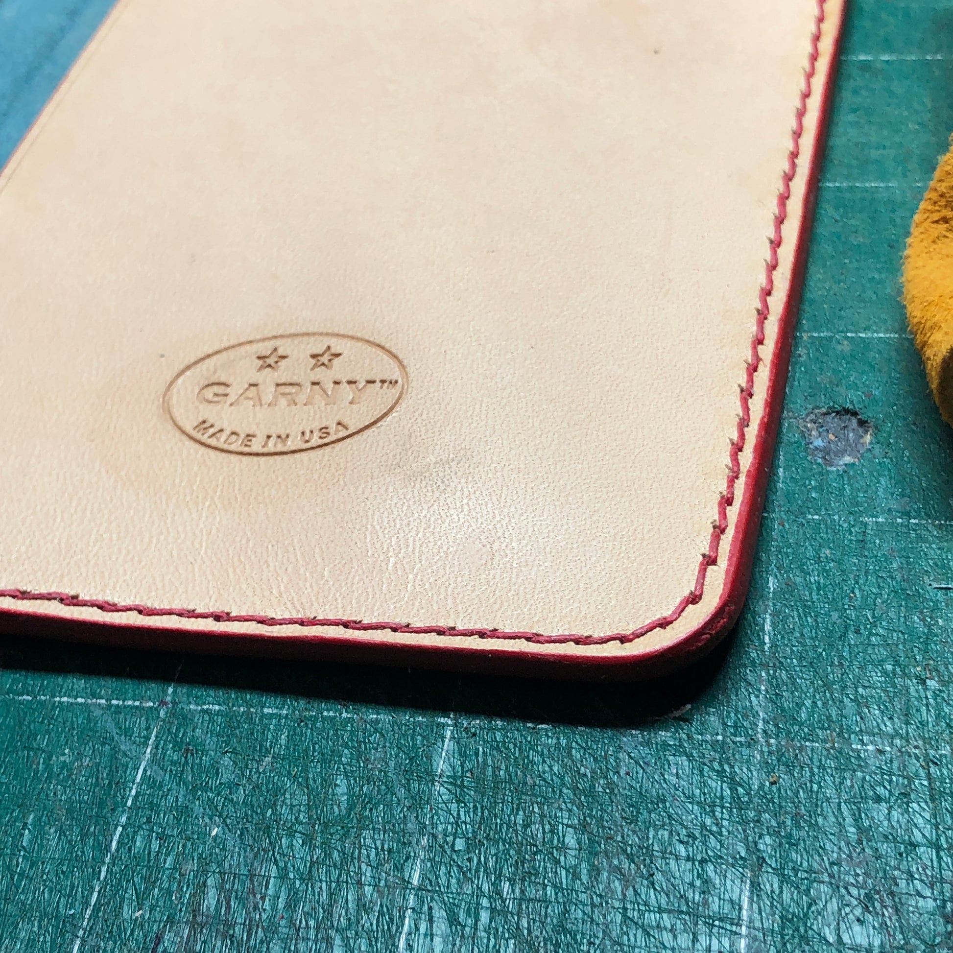 Hand stitching and finished edge of a Leather Field Notes cover with 2 pockets. 