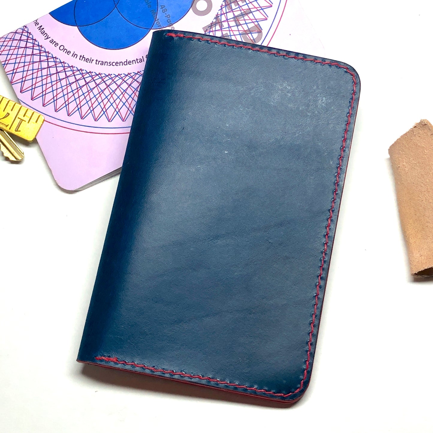 Blue leather notebook with red stitching on a white background