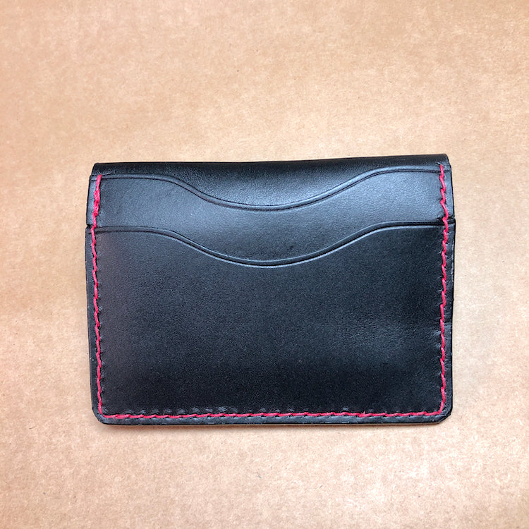 Black minimalist wallet, everyday carry, black leather wallet with red stitching.