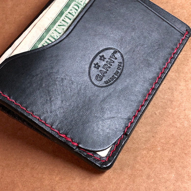 Black minimalist wallet, everyday carry, black leather wallet with red stitching.