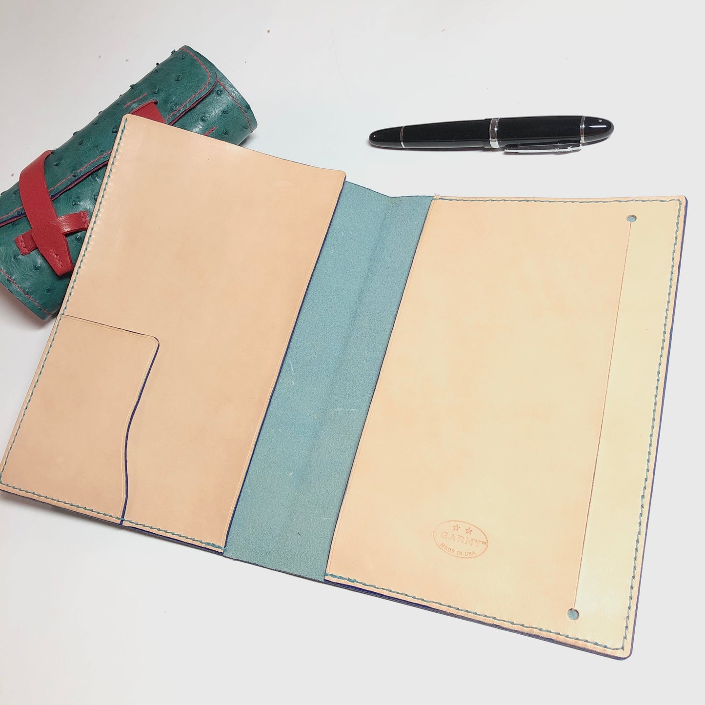 Leather-bound notebook with a pen on a white background
