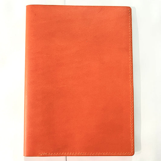 A bright orange cowhide  leather notebook cover or passport holder with visible hand stitching on a plain white background.