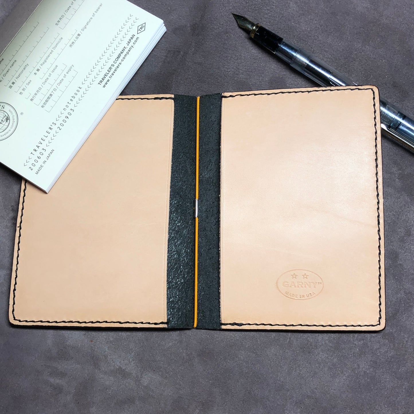 Inside pockets of a cowhide leather Passport size Travelers Journal cover.  Hand stitched, finished edges. One Midori Travelers Notebook Journal included.  