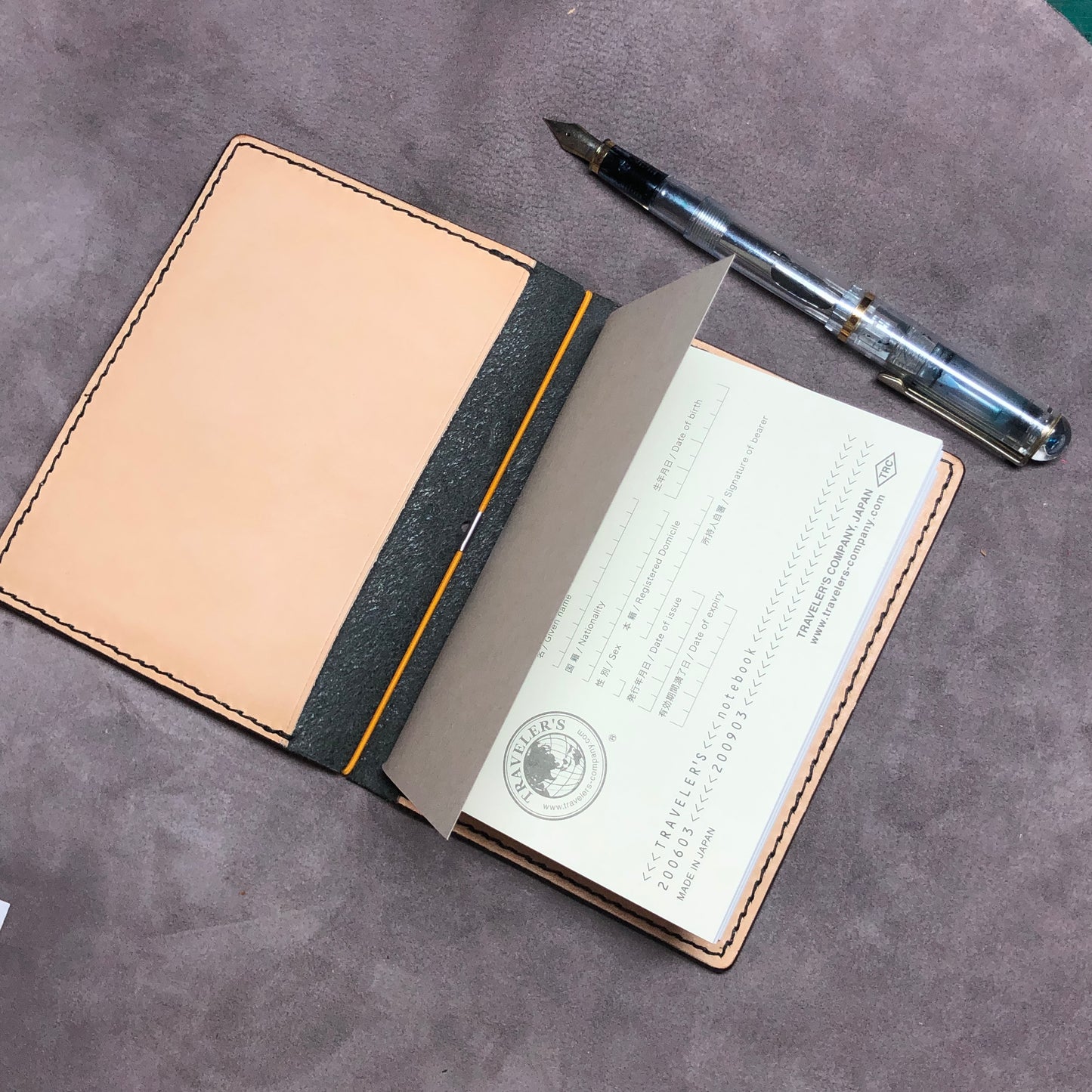 Inside pocket of a cowhide leather Passport size Travelers Journal cover.  Hand stitched, finished edges. One Midori Travelers Notebook Journal included.  