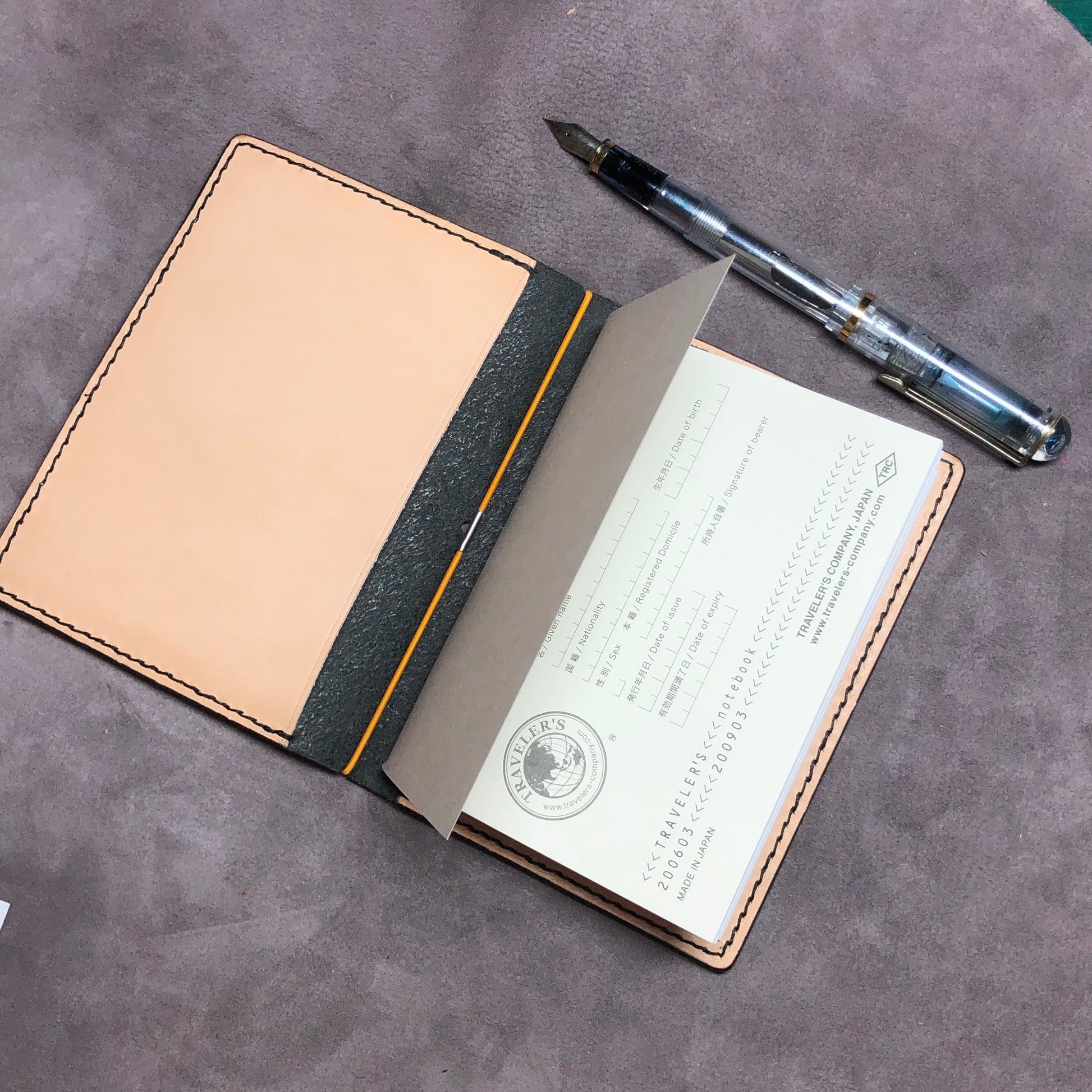 Inside pocket of a cowhide leather Passport size Travelers Journal cover.  Hand stitched, finished edges. One Midori Travelers Notebook Journal included.  