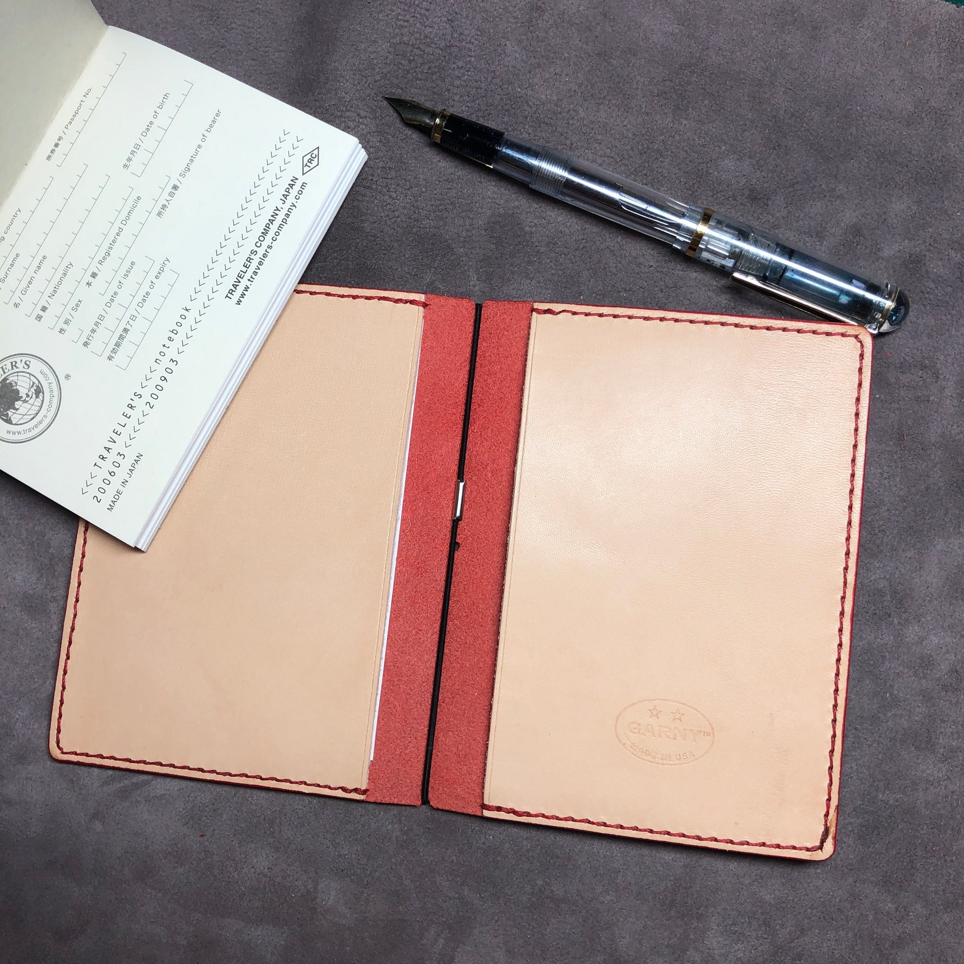 Inside pockets of a red cowhide leather Passport size Travelers Journal cover.  Hand stitched, finished edges. One Midori Travelers Notebook Journal included.  Refillable, pocket-size. 