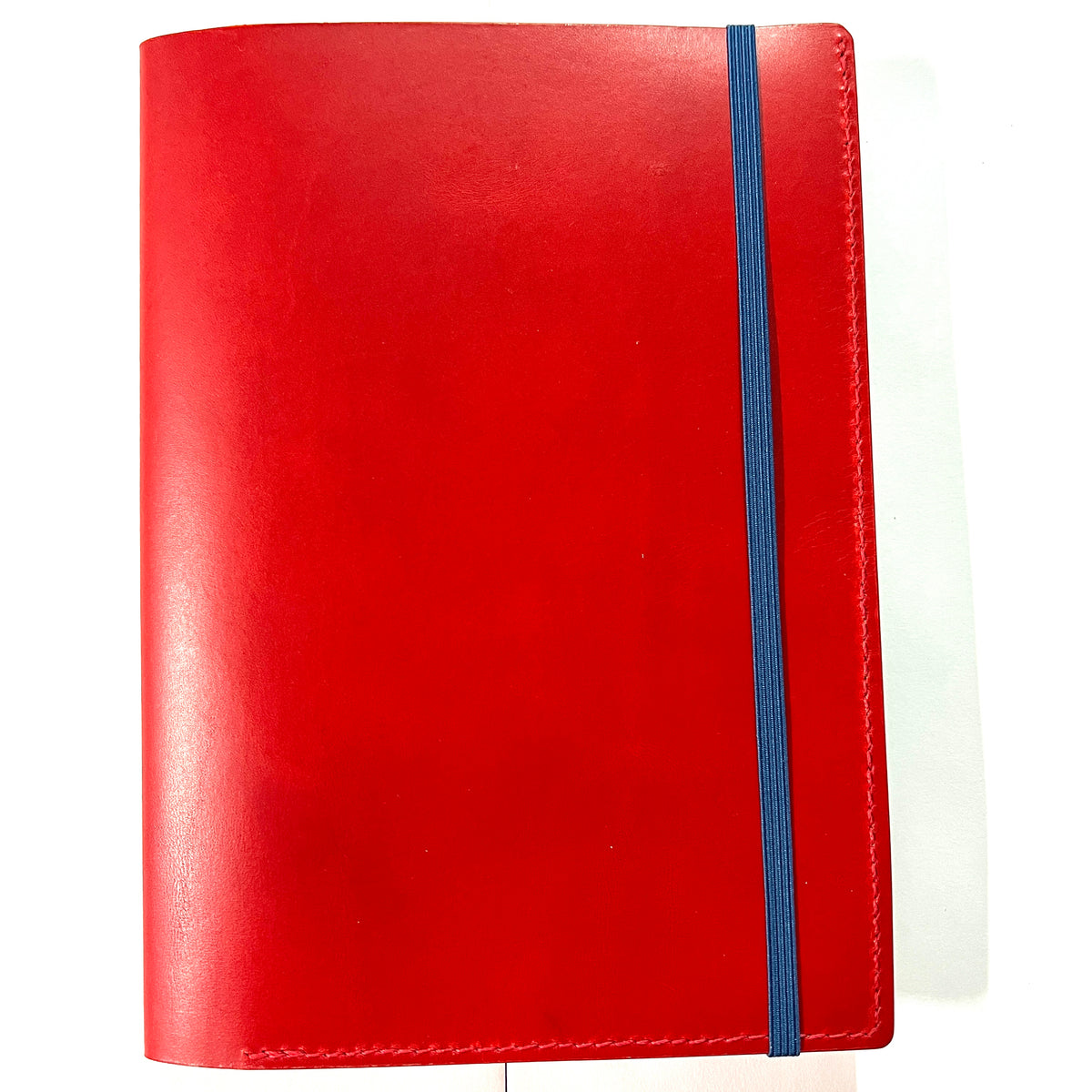 A red leather planner cover with a blue elastic closure band, shown on a plain white background.